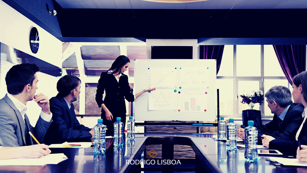 Executiva apresentando indicadores de treinamento para a equipe em uma sala de reunião