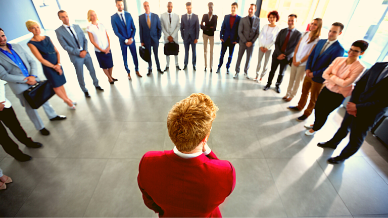 Líder se dirigindo a um grande grupo de colaboradores reunidos ao seu redor